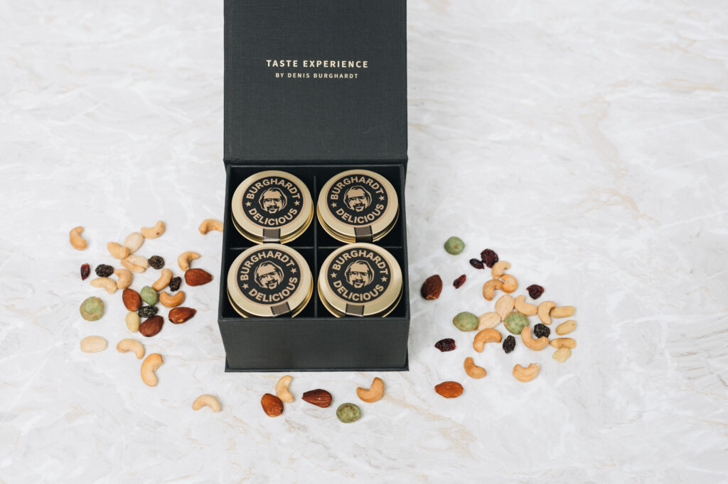 Burghardt Box mit einer Auswahl an vier Premium Glasdosen gefüllt mit Nussmischungen, Schokolade oder Trockenfrüchten.