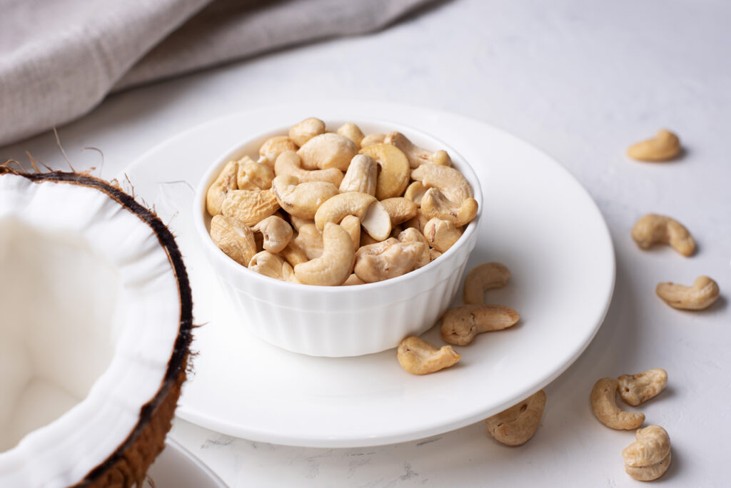 Frisch geröstete Cashewnüsse in einer Schüssel kombiniert mit Kokosnuss
