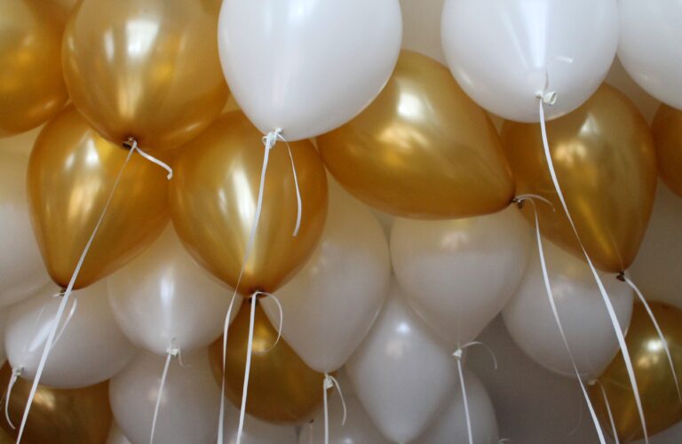 Luftballons gefüllt mit Helium in Gold und Weiß